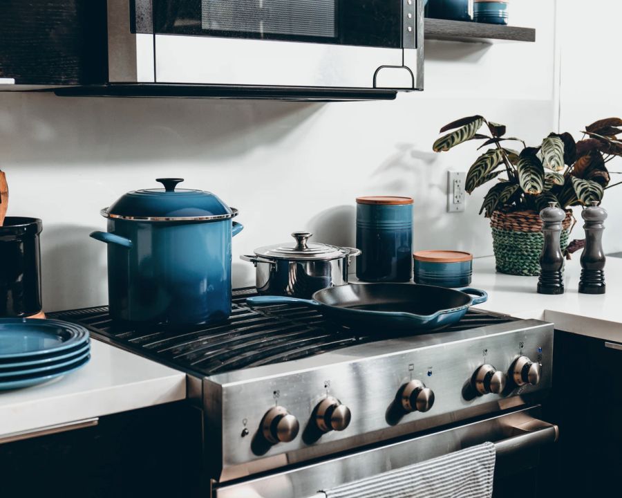 a large-sized blue slow cooker placed on a stove in the kitchen