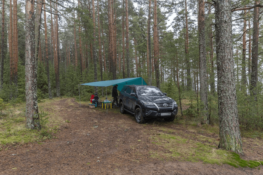 a stopover area, a car with a tent, and a family 