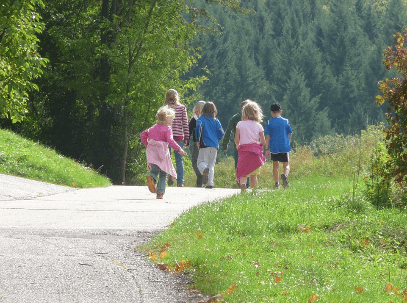 kids and their parents walking on a road