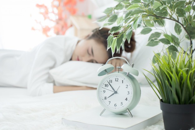 woman-asleep-bed-while-her-alarm-shows-early-time-home-bedroom